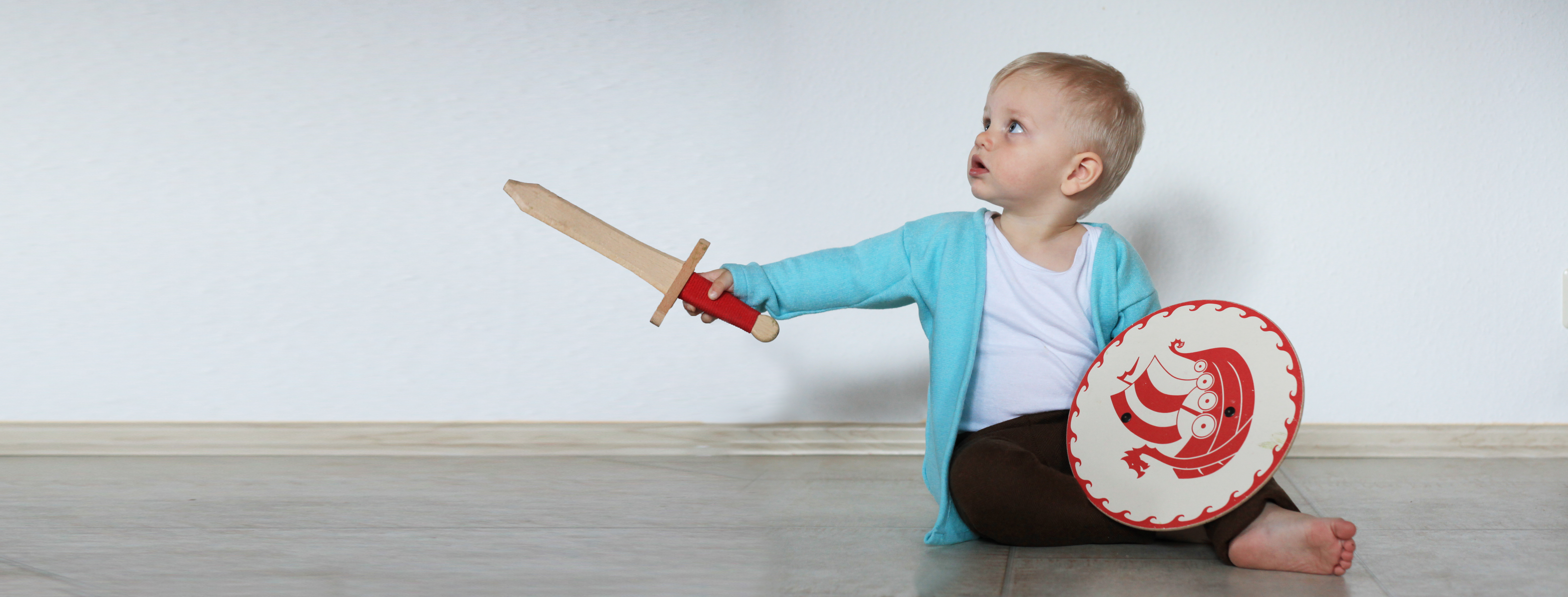 Titelbild Kindergwandung Kleinkind mit Schild und Schwert in der Hand