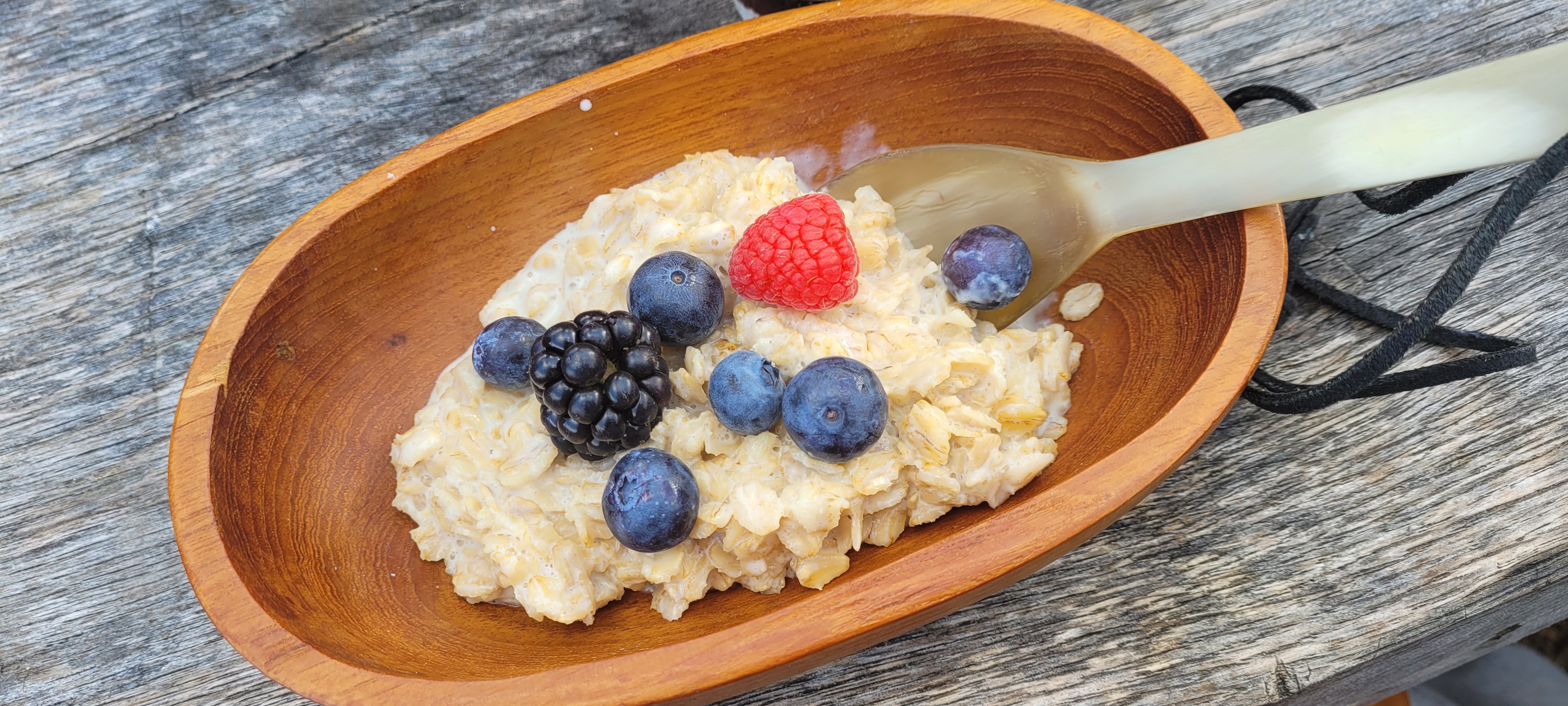 Haferbrei Frühstück Haferbrei mit Beeren in einer Holzschale