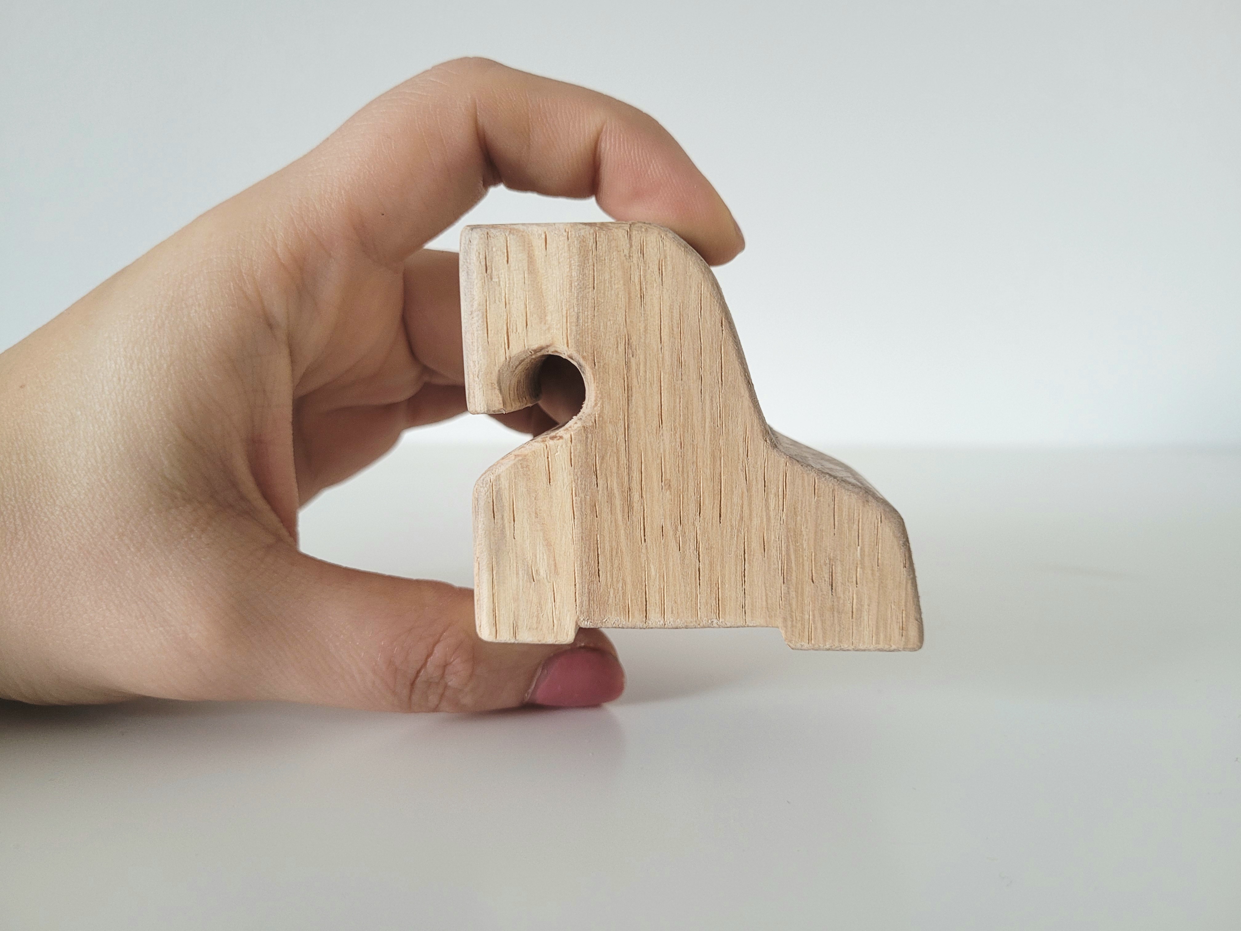 Pferdchen Größendarstellung Eine Hand hält ein Holzfpferdchen zur besseren Darstellung der Größe.